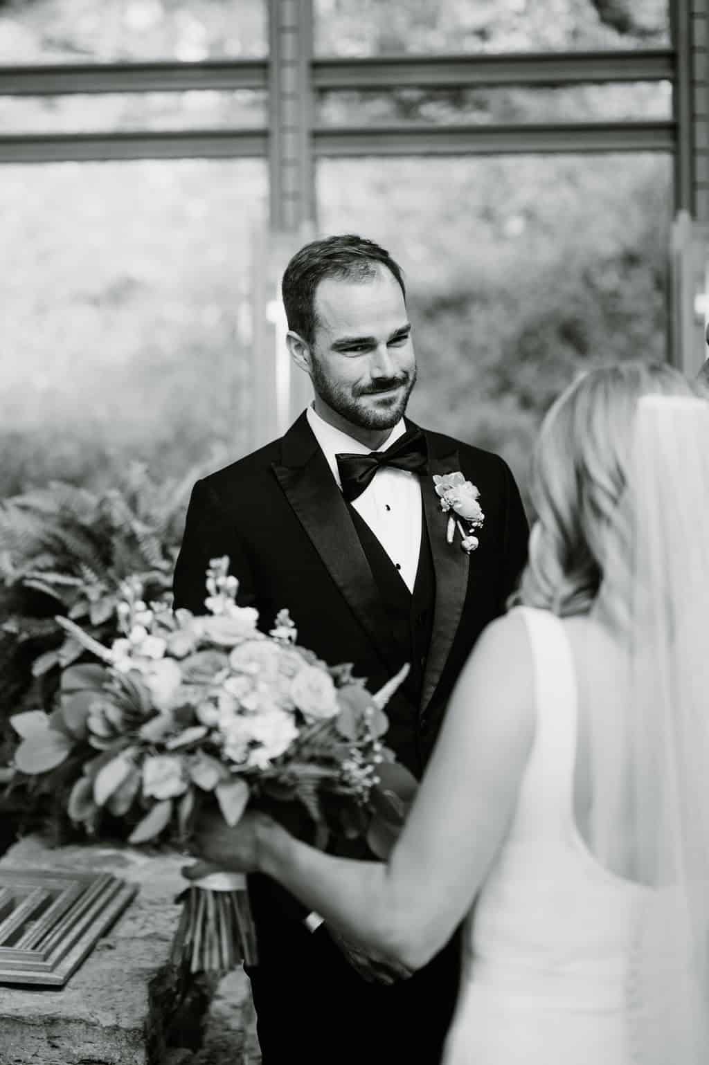 groom looking at bride down the aisle at thorncrown chapel
