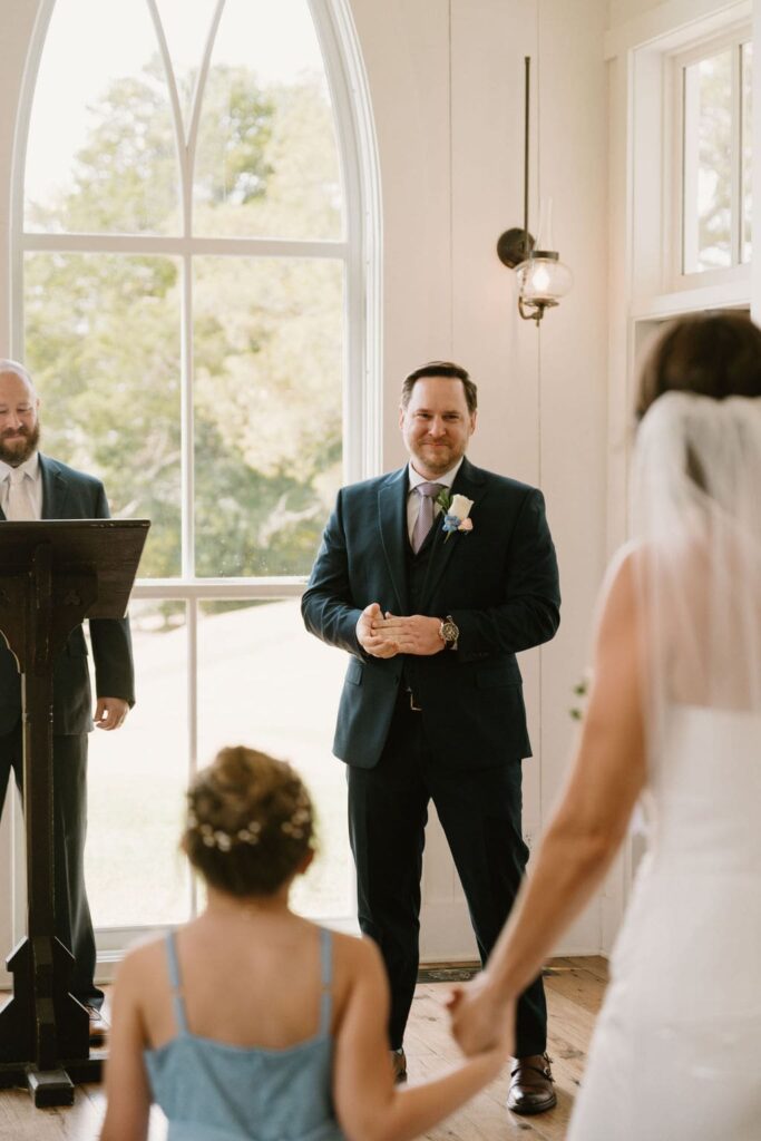 groom smiling at end of aisle