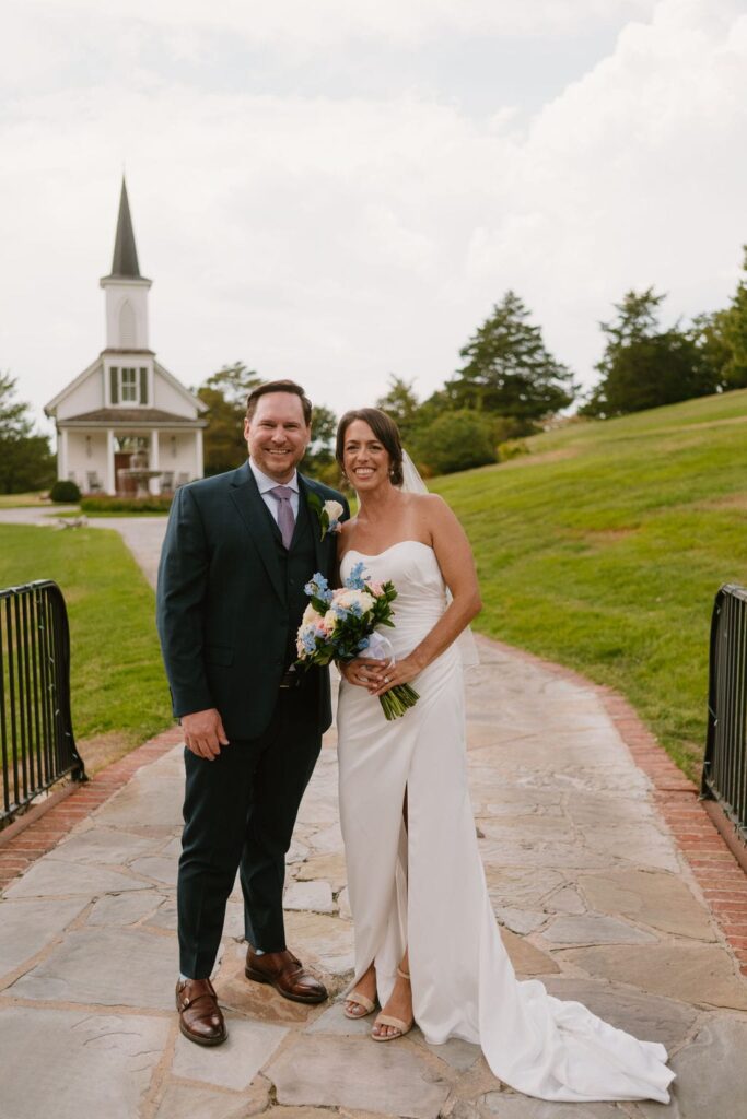 bride and groom smiling at the garden chapel after wedding 